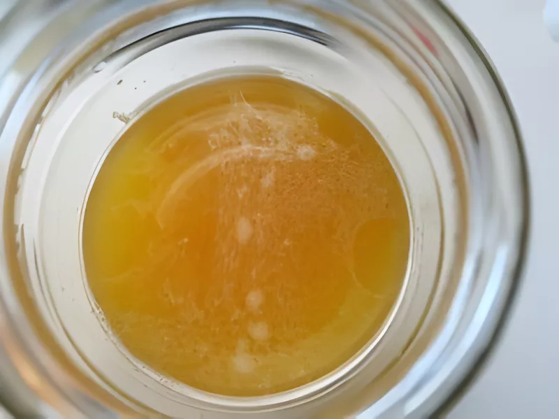 Overhead view of passion fruit mixture infusing in a jar.