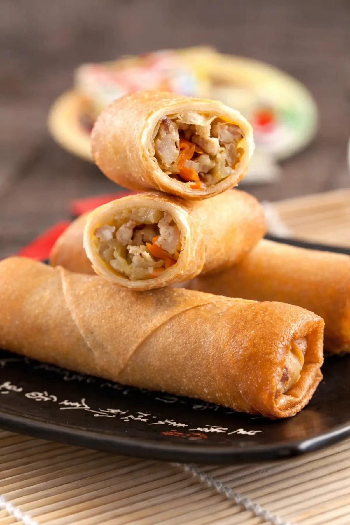Close-up of crispy spring rolls cut open showing chicken and vegetable filling.
