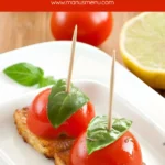 Tomato and basil skewers on halloumi squares served on a white dish.