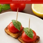 Cherry Tomato and Halloumi Bites served with fresh basil on a ceramic plate over a wooden board.