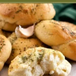 Golden bread knots topped with garlic and dried herbs.