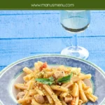 Swordfish and pistachio pasta on a plate.