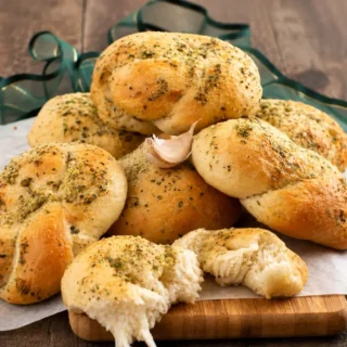 Golden bread knots topped with garlic and dried herbs.