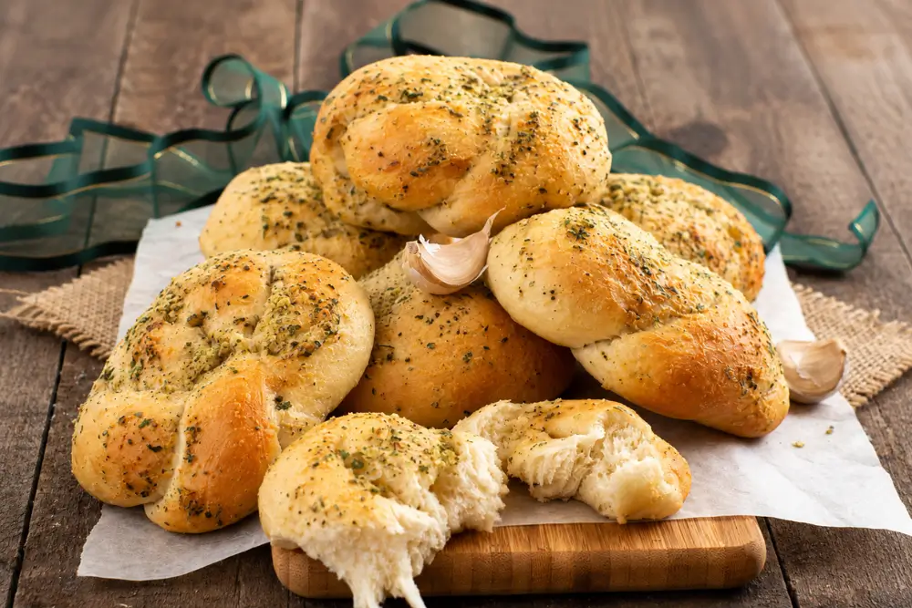 Golden bread knots topped with garlic and dried herbs.
