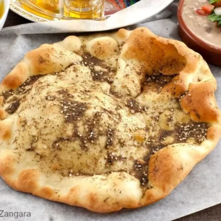 Close-up of Lebanese Za’atar Manouche showing golden crust and olive-oil-zaatar topping.