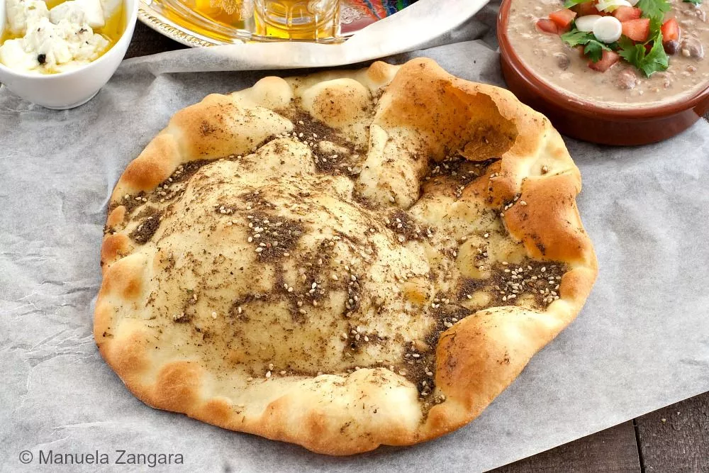 Close-up of Lebanese Za’atar Manouche showing golden crust and olive-oil-zaatar topping.