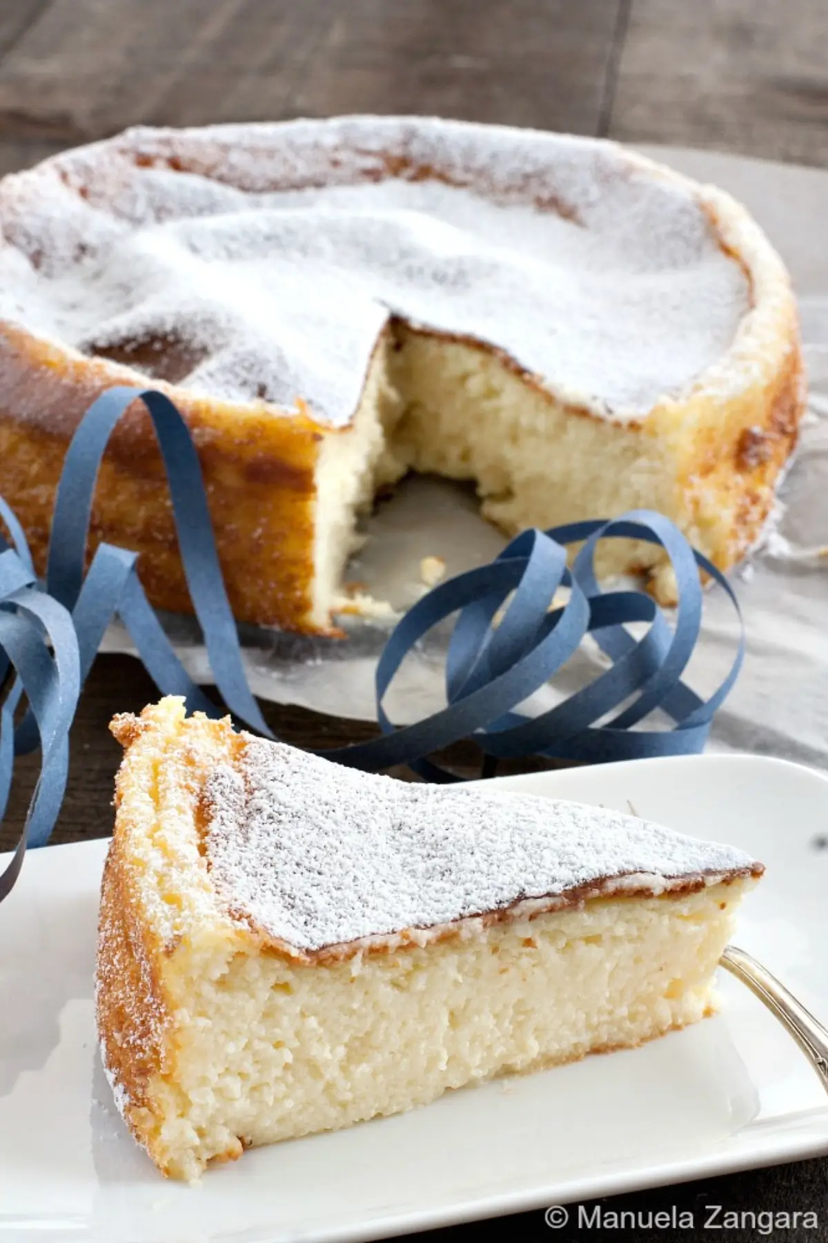 Slice of Migliaccio with creamy semolina and ricotta texture dusted with icing sugar.