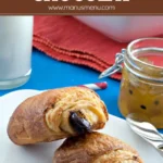 "Finished pain au chocolat with flaky layers and dark chocolate filling on a serving plate.