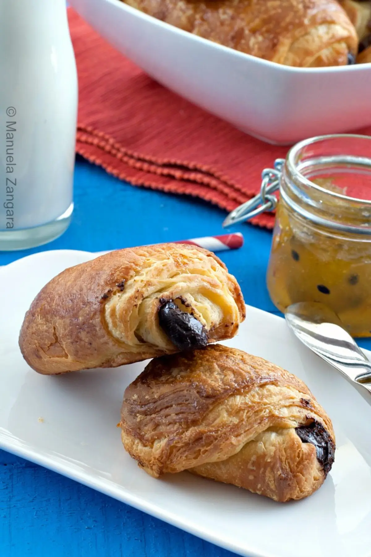 Two baked pastries served on a white plate.