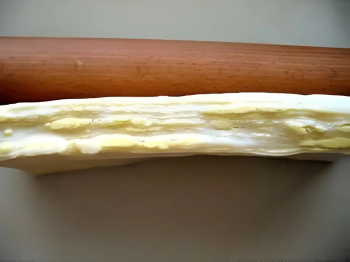 Cross section of laminated dough showing thin butter layers after rolling.