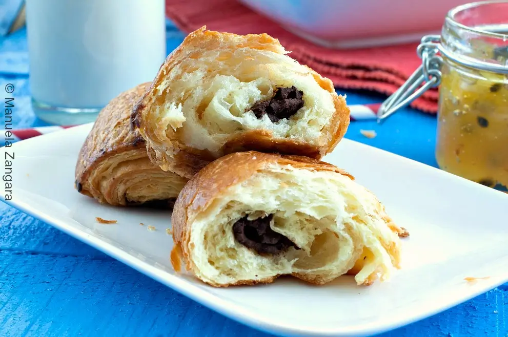Pain au chocolat cut open on a white plate.
