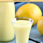 Small glass of Crema di Limoncello beside bottle and fresh lemons.