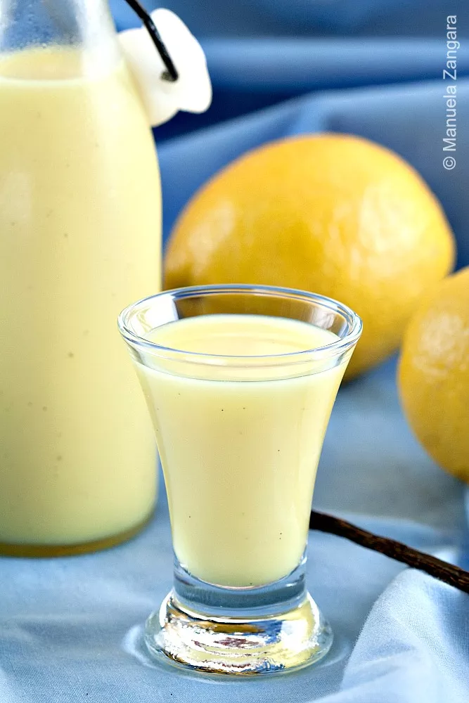 Close-up of Crema di Limoncello glass with lemons in background.