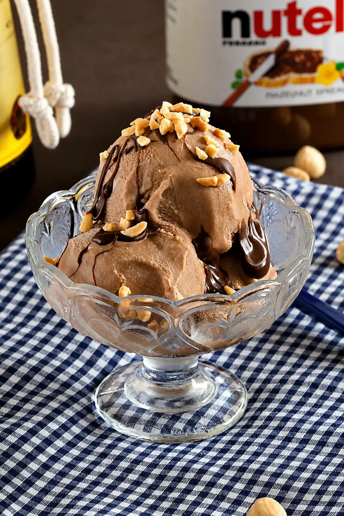 Nutella Gelato with Frangelico served in a glass bowl with crushed hazelnuts.