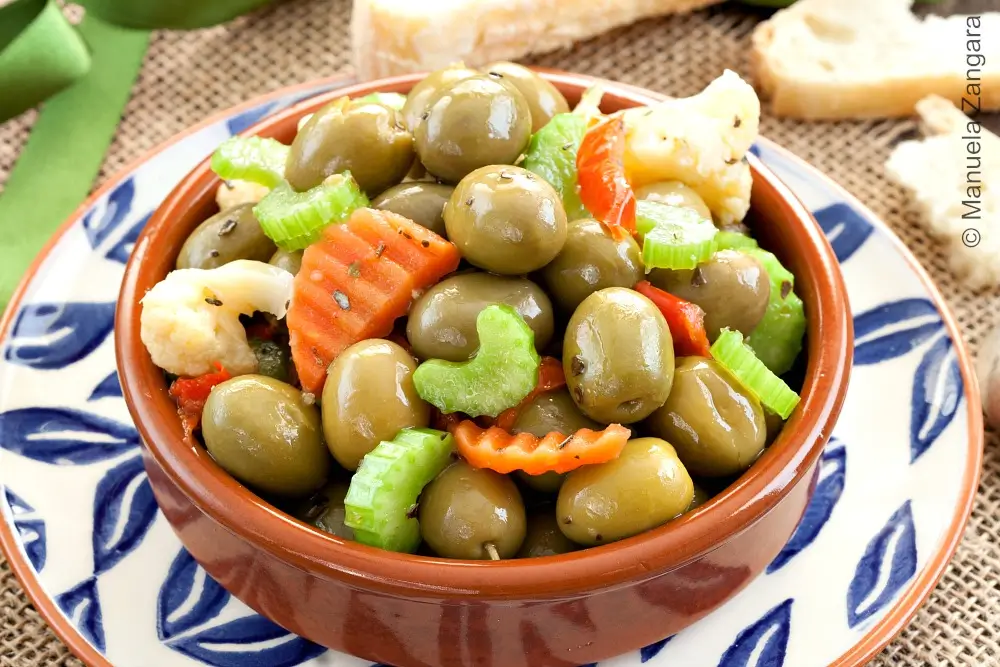 Close-up of Olive Schiacciate with green olives and chopped pickled vegetables.