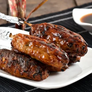 Tsukune chicken skewers brushed with glossy yakitori sauce after grilling.