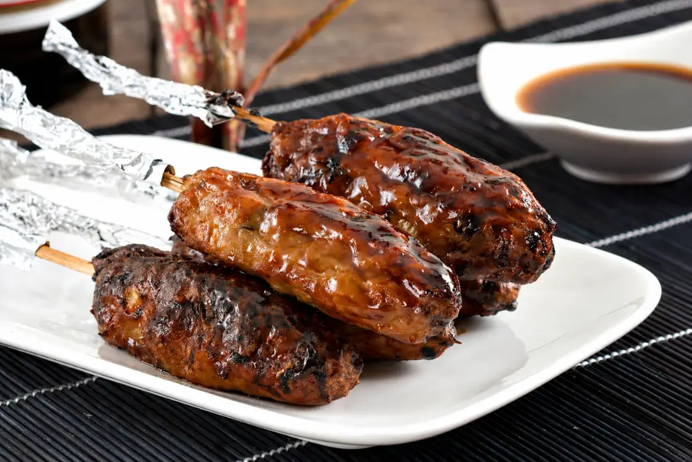 Tsukune chicken skewers brushed with glossy yakitori sauce after grilling.