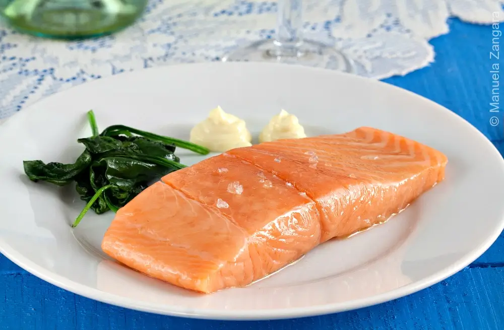 Salmon Confit served with homemade aioli on a white plate.