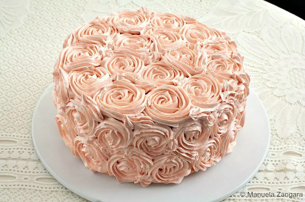 Whole rosette cake covered in pale pink buttercream roses.