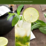 Green Tea Mojito served in a tall glass with mint leaves, lime slices, and ice.