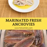 Marinated anchovies served with olive oil, garlic pieces, and chilli flakes in a shallow white bowl.