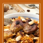 Saudi Chicken Kabsa with spiced rice, garnished with almonds and raisins.