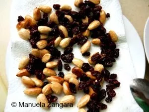 Fried almonds and raisins drained on paper towel.