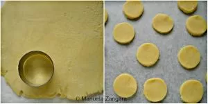Rolled shortbread dough cut into small round cookies on parchment paper.