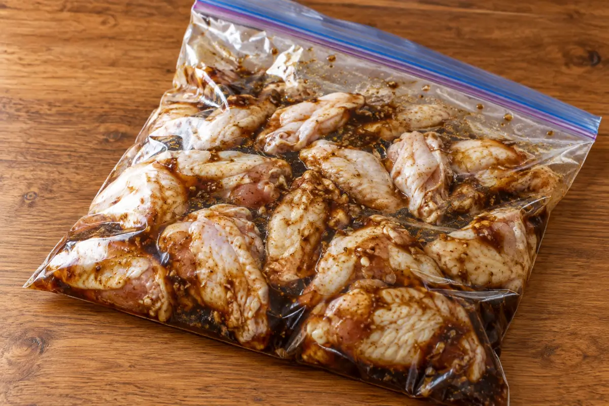 Chicken wings coated with the soy, lime and five-spice marinade in a sealed bag.