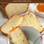 Slice of yogurt plumcake dipped into a bowl of milk.