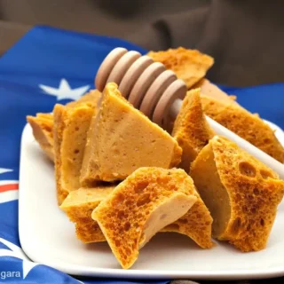 Honeycomb pieces arranged on a white plate with an Australian flag behind them.
