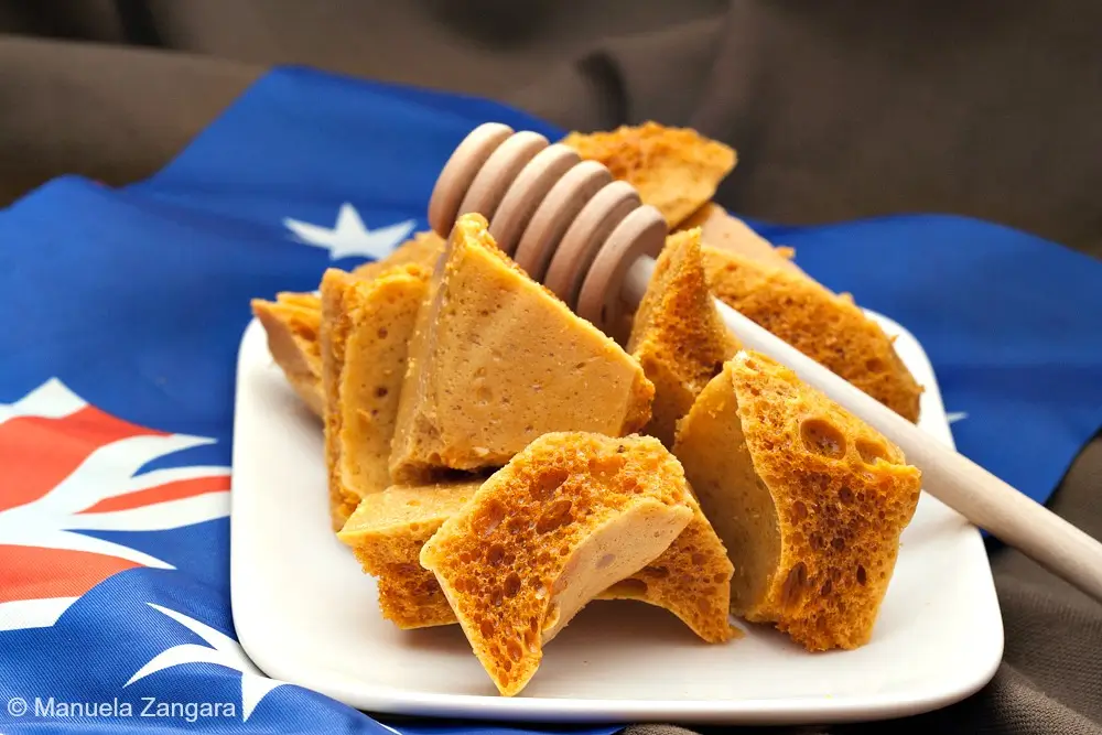 Honeycomb pieces arranged on a white plate with an Australian flag behind them.