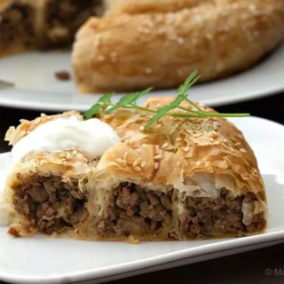 Traditional Bosnian burek spiral baked until golden and sprinkled with sesame seeds.
