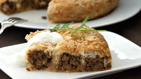 Traditional Bosnian burek spiral baked until golden and sprinkled with sesame seeds.