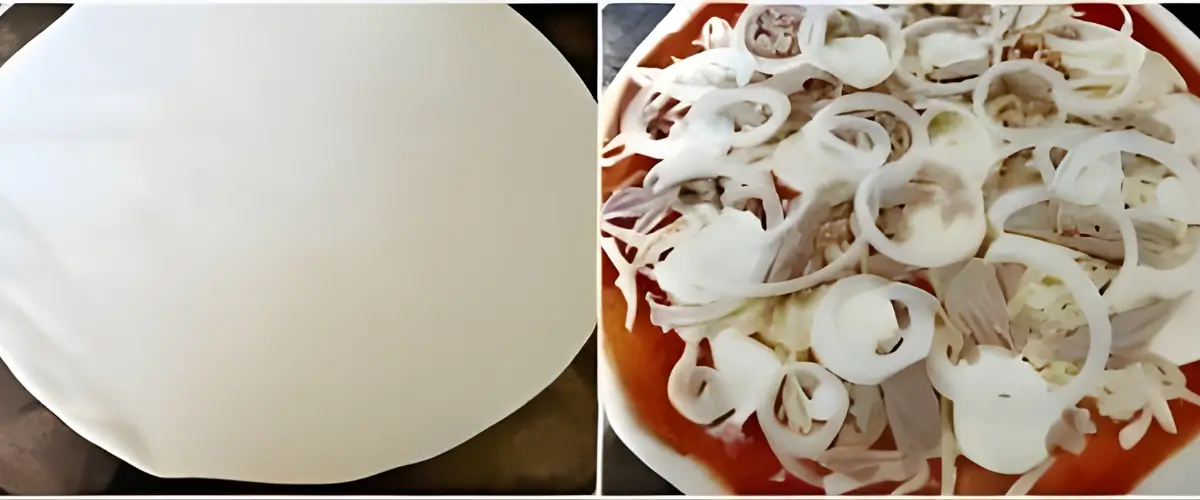 Rolled pizza dough next to a pizza topped with tomato sauce, tuna, mozzarella, and sliced onions.