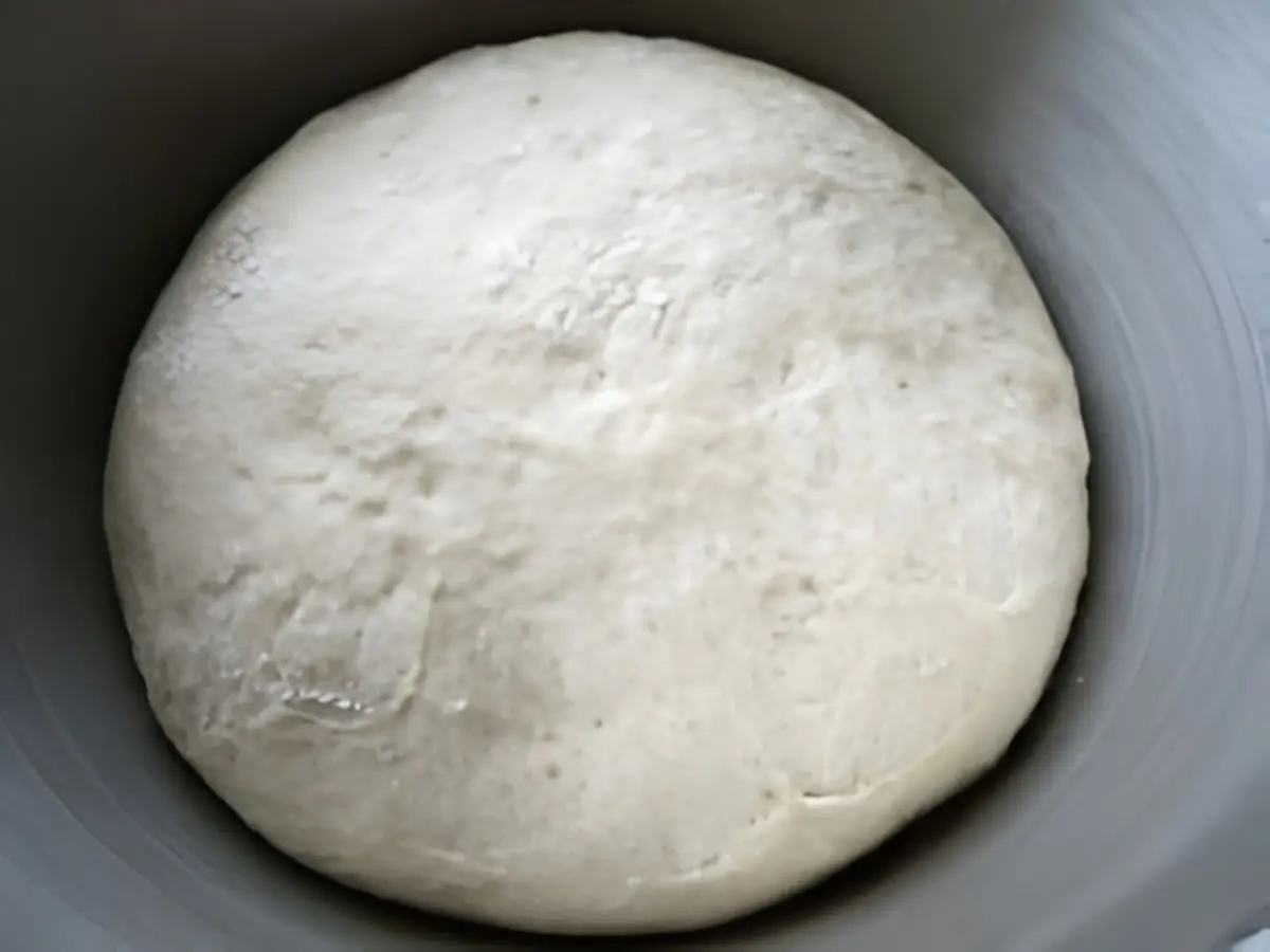 Bowl with risen pizza dough ready to be shaped.