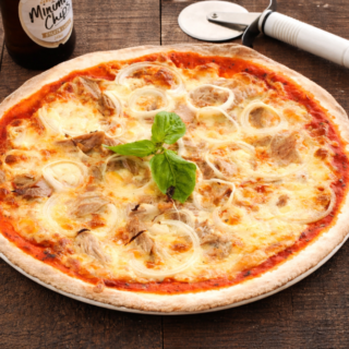 Freshly baked tuna and onion pizza with melted mozzarella, tender tuna pieces, and soft onion rings topped with basil.