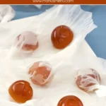Wrapped honey hard candies on parchment paper.