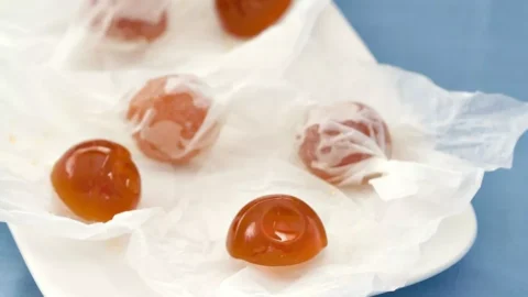 Wrapped honey hard candies on parchment paper.