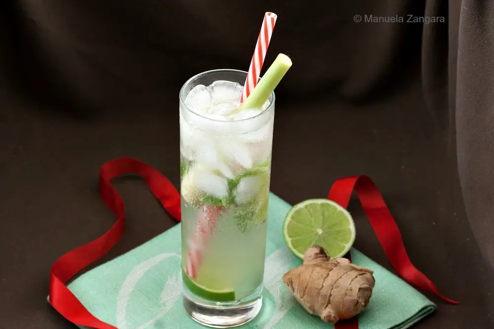 Lemongrass and Ginger Mojito served in a tall glass with crushed ice, lime, mint, and fresh ginger on the side.