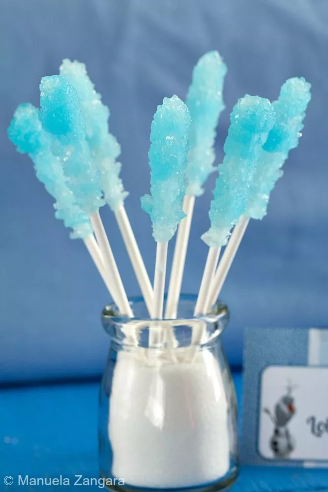 Blue rock candy lollipops in a small glass jar.