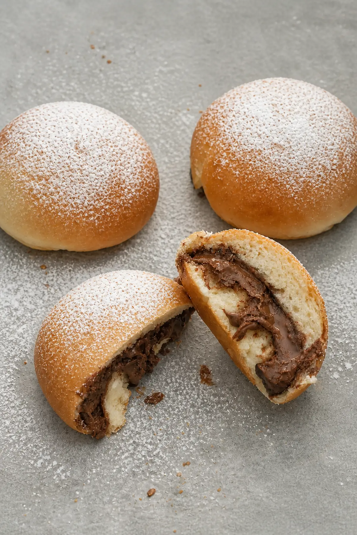 Soft Italian Nutella buns with powdered sugar and creamy chocolate filling inside.