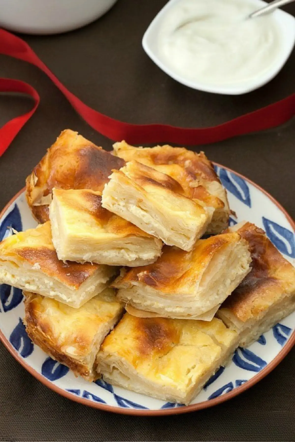Golden slices of baked sweet yoghurt burek arranged on a plate.