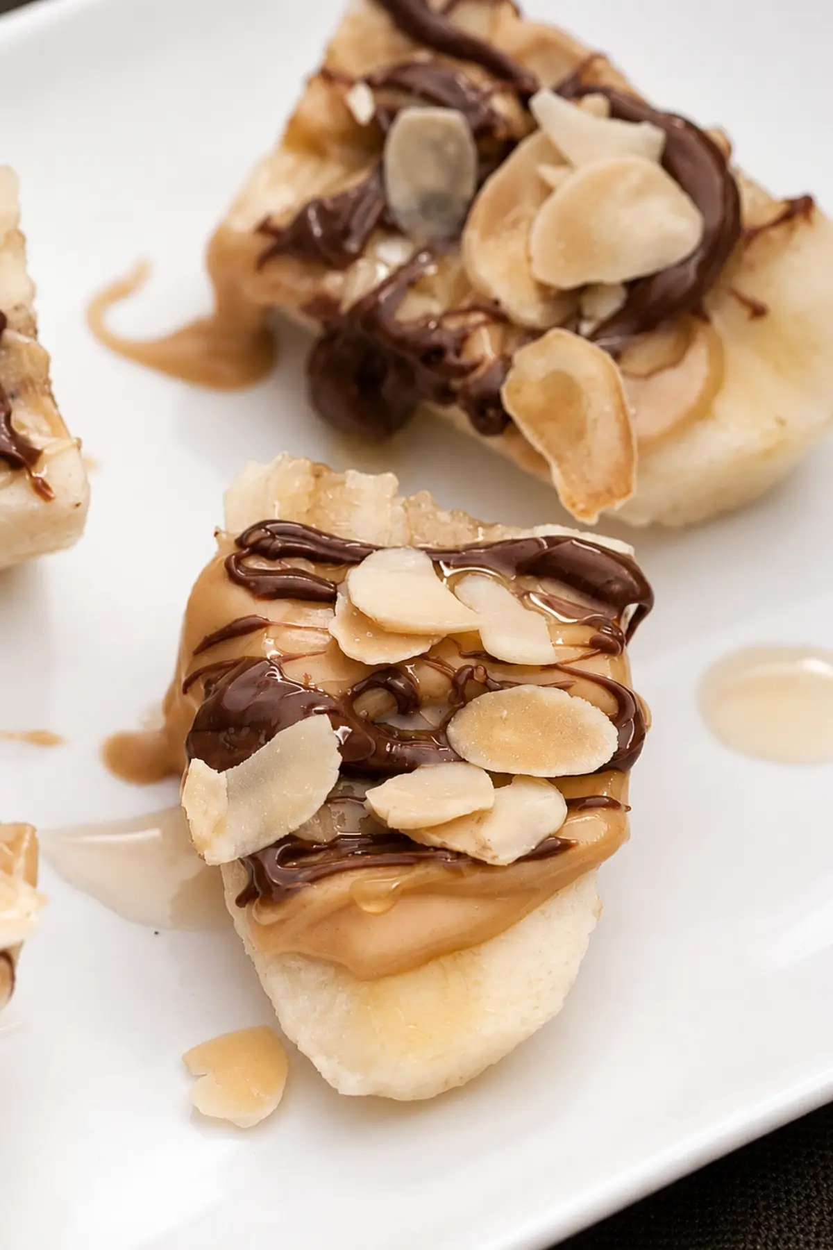 Close-up of a Nutella banana bite with peanut butter, honey, and toasted almonds.