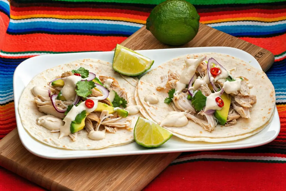 Quick chicken tacos filled with shredded chicken, fresh toppings, and drizzled with lime dressing.