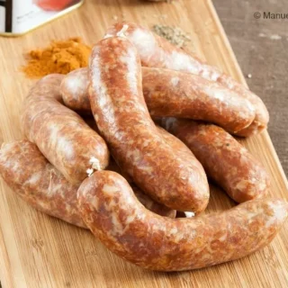 Raw homemade Spanish chorizo arranged on a wooden board.