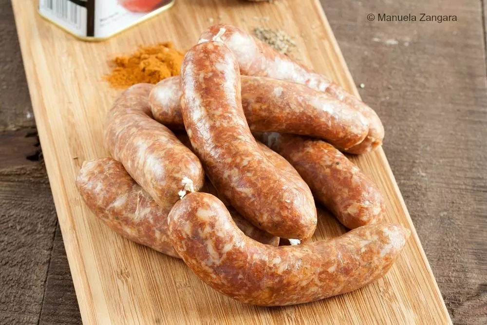 Raw homemade Spanish chorizo arranged on a wooden board.