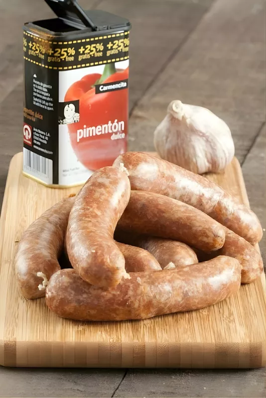 Homemade Spanish chorizo with pimentón dulce and garlic on a cutting board.