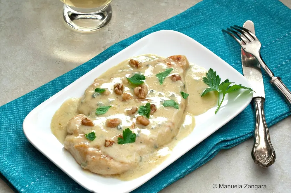 Close-up of Chicken Gorgonzola with creamy sauce, walnuts and parsley.