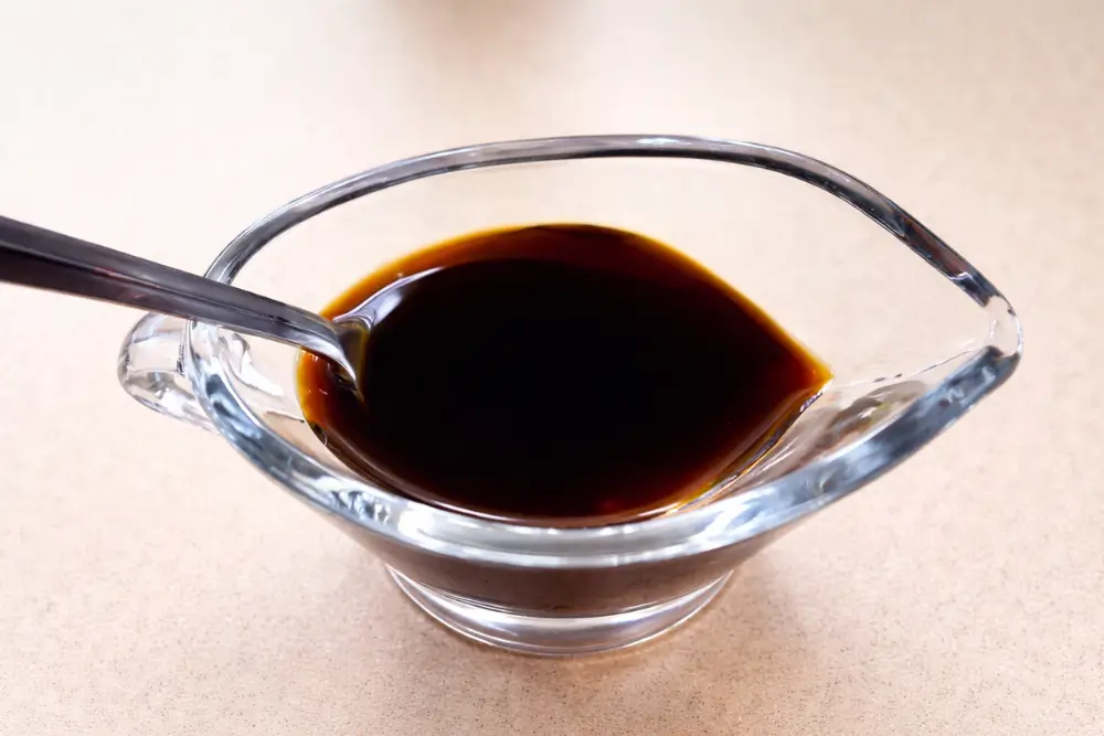 Ponzu sauce in a small glass bowl with a spoon.